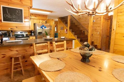 cocina con mesa de madera y comedor en Lazy Bear Cabin en Sevierville