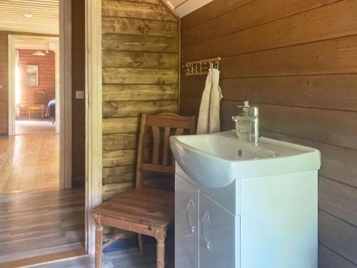 een badkamer met een wastafel en een houten muur bij Holiday home ÖRSJÖ in Örsjö