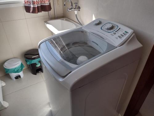 uma máquina de lavar roupa na casa de banho com um lavatório em Home Office Curitiba/vaga de estacionamento grátis em Curitiba