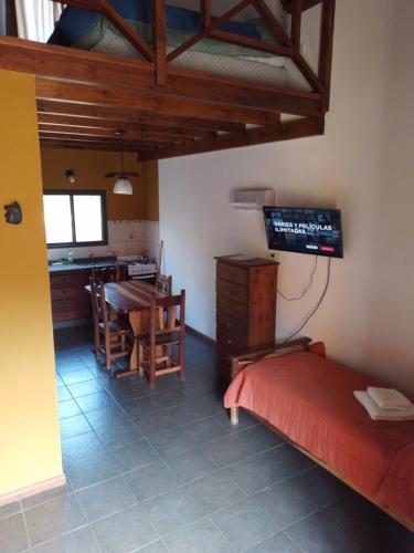 Habitación con cama, mesa y cocina. en Barranca Del Indio en Merlo