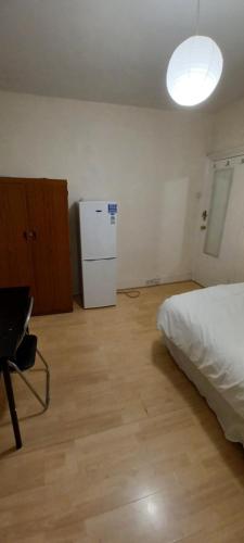 a bedroom with a bed and a white refrigerator at Bruce Rooms in London
