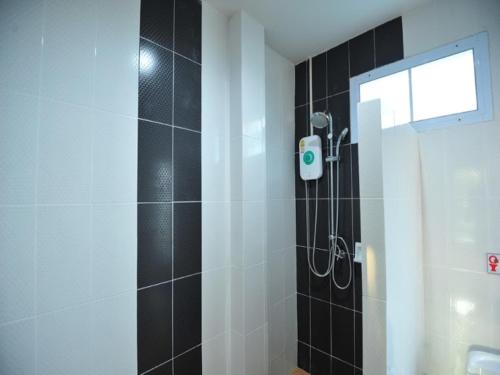 a bathroom with a shower with black and white tiles at Park & Pool Resort in Nong Khai