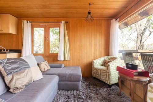 a living room with a couch and a chair at Woodland Cabins in Santa Ana Jilotzingo