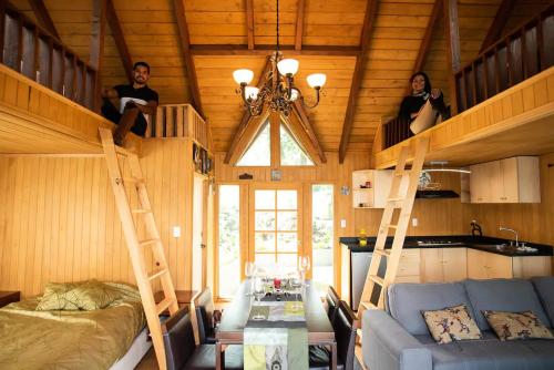 two people sitting on bunk beds in a tiny house at Woodland Cabins in Santa Ana Jilotzingo