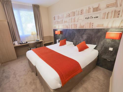 Habitación de hotel con cama y escritorio en Kyriad Angers Ouest Beaucouzé en Beaucouzé