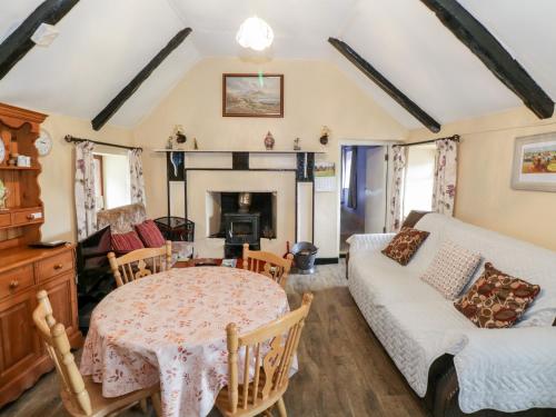 a living room with a table and a couch at The Thatched Cottage in Liscarney