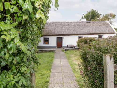 a cottage with a pathway leading to the front door at The Thatched Cottage in Liscarney