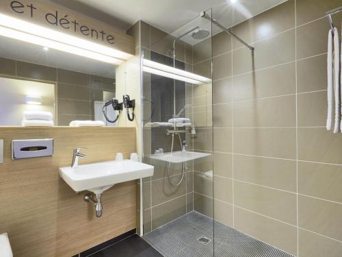 een badkamer met een wastafel en een douche bij Kyriad Angers Ouest Beaucouzé in Beaucouzé