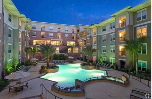 a large swimming pool in a courtyard in a building at Stylish Open Concept Apt with King Bed, walking distance from NRG Texans Stadium, 1 mile to Med Center, Free Parking in Houston