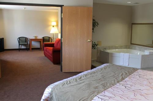 a hotel room with a bed and a bath tub at Edmore Inn in Edmore