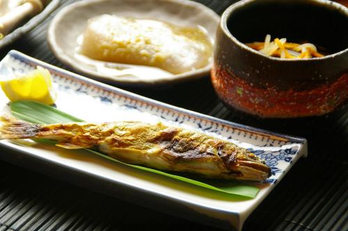 a plate with a piece of fish and a bowl of food at Kirinosato Takahara in Tanabe