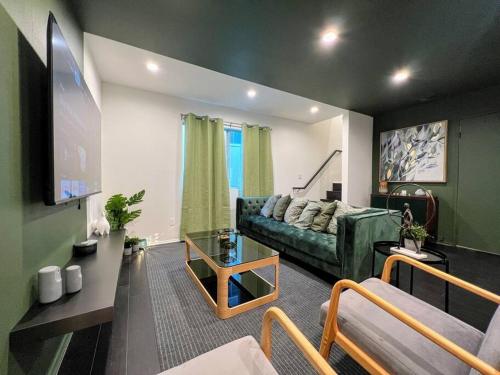 a living room with a green couch and a flat screen tv at Hollywood Green Habitat in Los Angeles