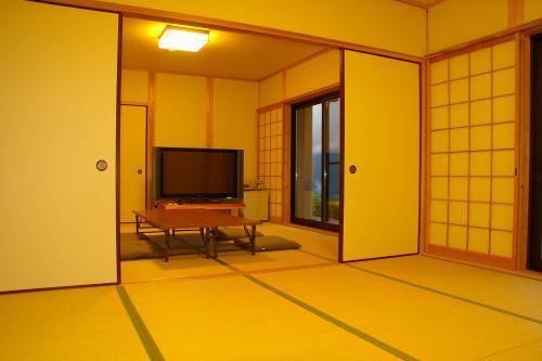a room with a television and a table in a room at Kirinosato Takahara in Tanabe