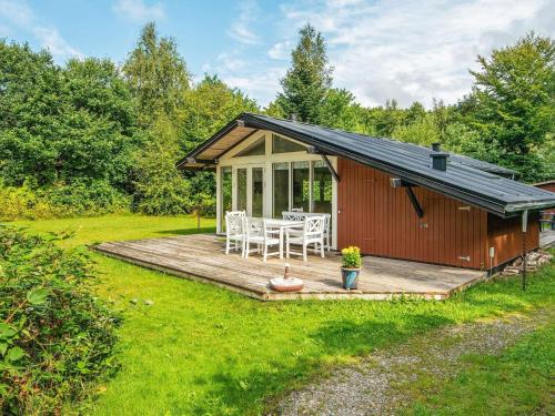 a cabin with a deck and a table and chairs at 5 person holiday home in Ry in Ry
