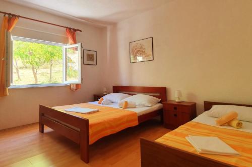 1 dormitorio con 2 camas y ventana en Apartment Metajna 6423c en Metajna
