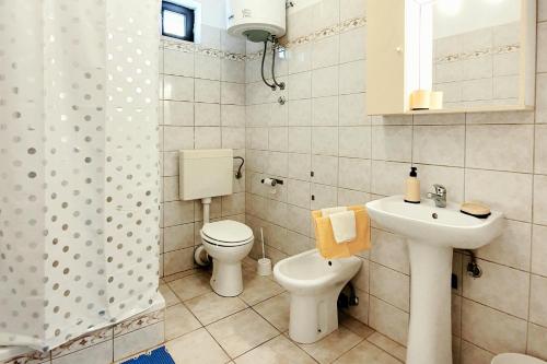 y baño con aseo, lavabo y ducha. en Apartment Metajna 6423c en Metajna