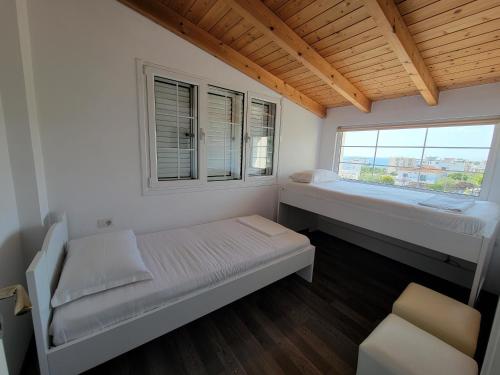 1 dormitorio con 2 camas y ventana en Villa August Ksamil, en Ksamil