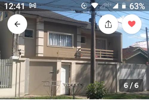 een huis met twee pijlborden aan de zijkant bij Suite/loft Jardim Botanico in Curitiba