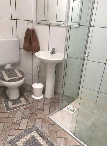 W łazience znajduje się toaleta, umywalka i prysznic. w obiekcie Suite/loft Jardim Botanico w mieście Kurytyba
