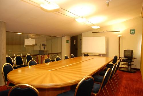 a conference room with a large wooden table and chairs at Hotel Donatello in Padova