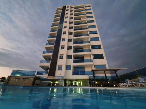 un edificio con piscina di fronte a un edificio di Apartamento Santa Marta Bello Horizonte Junto a Olímpica a Santa Marta