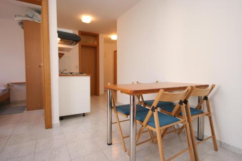 une cuisine avec une table en bois et deux chaises dans l'établissement Apartment Mandre 6405e, à Kolan