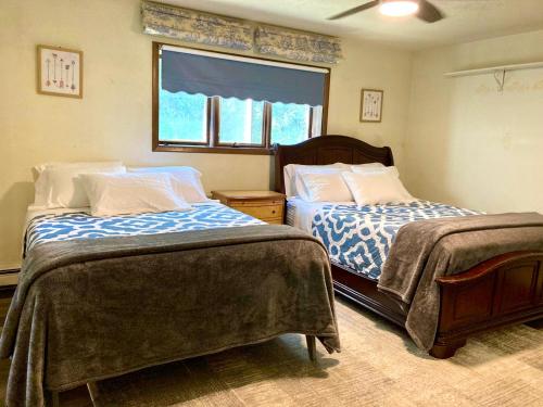 1 dormitorio con 2 camas y ventana en Spacious Resort Style Retreat Sleeps 20 en Fairbanks