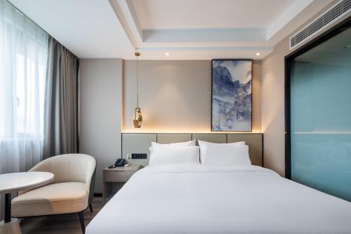 a hotel room with a bed and a table at Xinhuating Business Hotel in Lishui