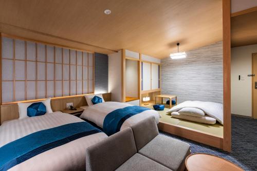 a hotel room with two beds and a couch at Rinn Niomon in Kyoto