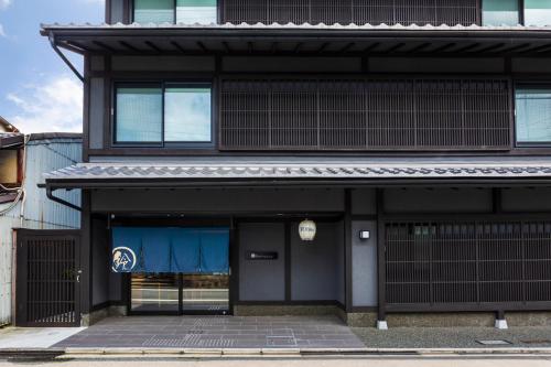 un edificio nero con un cartello blu sopra di Rinn Niomon a Kyoto