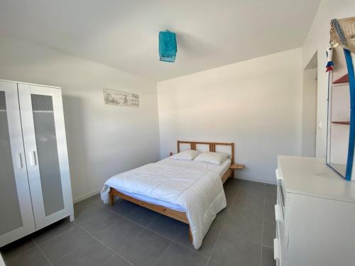 sypialnia z łóżkiem w białym pokoju w obiekcie Maison Bretignolles-sur-Mer, 5 pièces, 10 personnes - FR-1-231-76 w mieście Brétignolles-sur-Mer