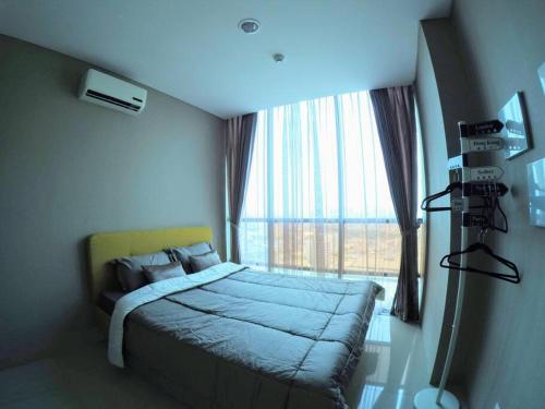 a bedroom with a bed and a large window at Strategic Cozy Hang Out Apartment, GP Plaza in Jakarta