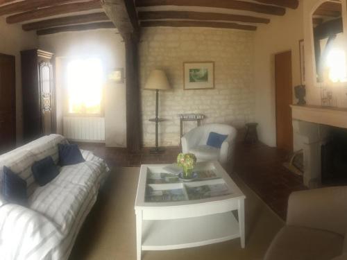 ein Wohnzimmer mit einem Sofa und einem Couchtisch in der Unterkunft Gîte Parçay-sur-Vienne, 3 pièces, 4 personnes - FR-1-381-440 in Parçay-sur-Vienne