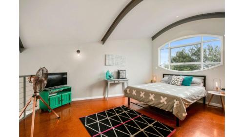a bedroom with a bed and a tv and a window at Surf Sounds in Inverloch