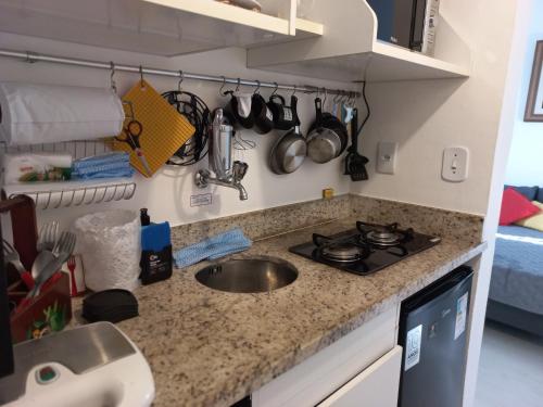 a kitchen counter with a sink and a stove at Apartamento aconchegante em Petrópolis in Petrópolis