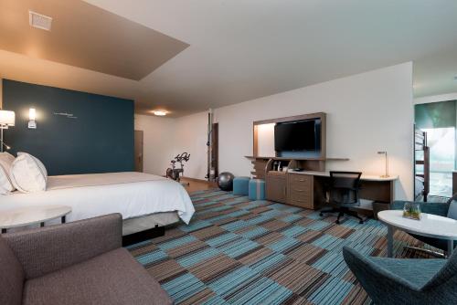 奥马哈EVEN Hotel Omaha Downtown - Old Market by IHG的一间配有床和平板电视的酒店房间