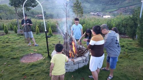 a group of people standing around a fire pit at KAZUO Village in Bao Loc