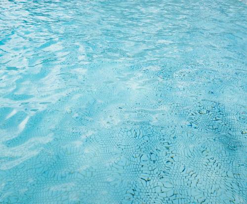 a pool of blue water with ripples in it at Garden Villa Hotel in Tumon