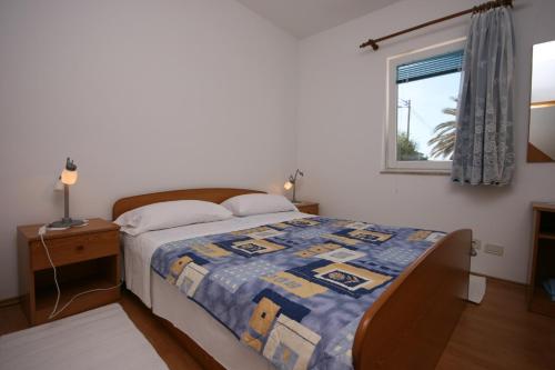 1 dormitorio con 1 cama con edredón en Apartment Stara Novalja 6301b, en Stara Novalja