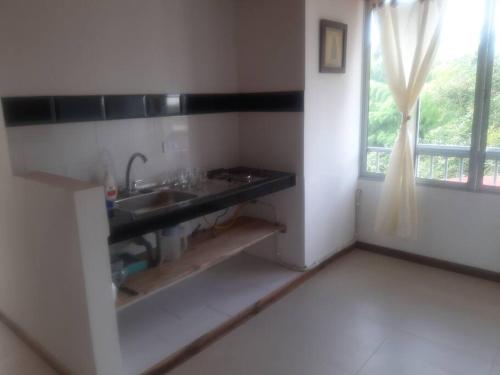 a kitchen with a sink and a window in a room at Apartamento pequeño, acogedor, 1 habitación, vista a zonas verdes, English in Calarcá