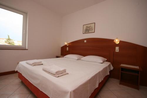 ein Schlafzimmer mit einem großen Bett mit Handtüchern darauf in der Unterkunft Apartment Novalja 6398e in Novalja