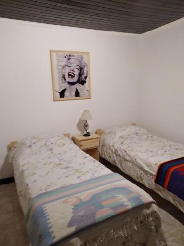 1 dormitorio con 2 camas y una foto en la pared en La Paz en Lobos