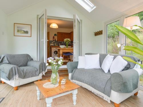 a living room with two couches and a table at Kestorway in Gidleigh