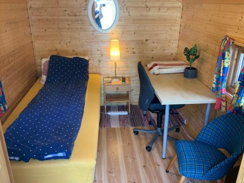 um pequeno quarto com uma cama e uma secretária em Your cabin in Trondheim em Tiller