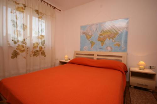 Un dormitorio con una cama naranja y un mapa en la pared en Apartments with WiFi Pula - 6987, en Pula