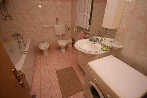 a bathroom with a sink and a toilet and a bath tub at Apartments with WiFi Pula - 6987 in Pula