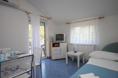 フンタナにあるApartments with a parking space Funtana, Porec - 7076のベッドとテレビとテーブルのある寝室
