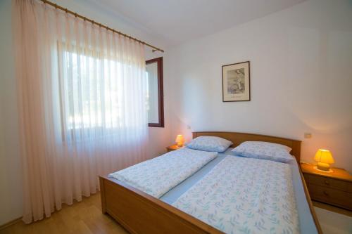 een slaapkamer met een bed en een raam bij Apartments with parking space Porec - 6984 in Poreč