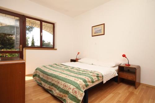 1 dormitorio con cama y ventana en Apartment Porec 7042b, en Poreč