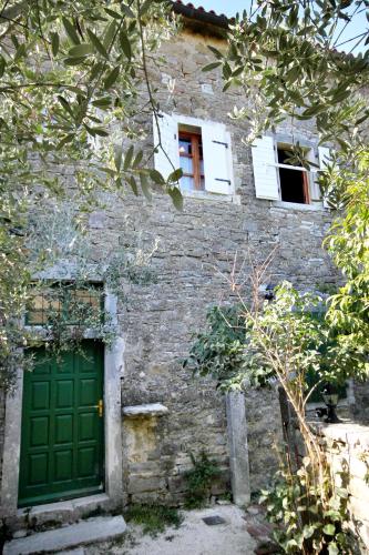 a brick building with a green door and two windows at Apartments with WiFi Groznjan, Central Istria - Sredisnja Istra - 7038 in Grožnjan